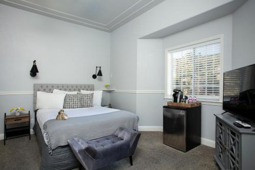 a bedroom with a bed with a teddy bear sitting on it at Hounds Tooth Inn in Oakhurst
