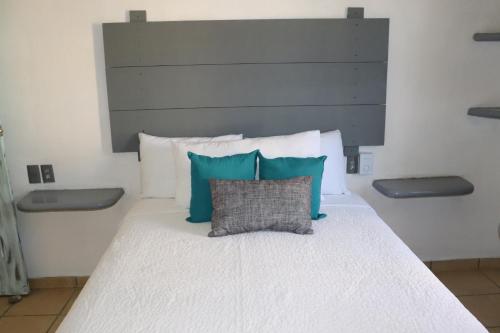 a bed with blue and white pillows on it at Habitaciones Samy in San Francisco