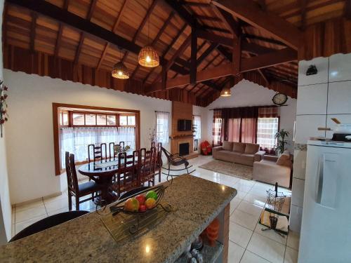a kitchen and living room with a table and a living room at Chalé Sonho Meu in Monte Verde