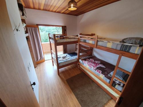 a room with two bunk beds in a house at Chalé Sonho Meu in Monte Verde