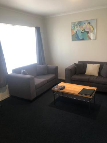 a living room with a couch and a coffee table at Claremonte Motor Lodge in Hastings