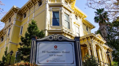 a yellow building with a sign in front of it at HI Sacramento Hostel in Sacramento