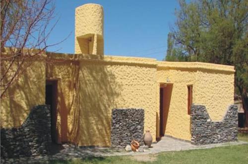un pequeño edificio con una chimenea encima en Cabañas Achalay en Santa María