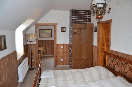 1 dormitorio con cama y lámpara de araña en Alėjos Ąžuolas, en Leipalingis