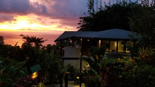 a house with a view of the ocean at sunset at Tulemar in Manuel Antonio