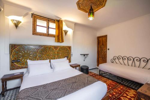 a bedroom with two beds and a window at Le Cèdre D'argent in Fès