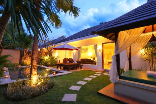 a backyard with a pool and a house at The Yubi Boutique Villas Seminyak - CHSE Certified in Seminyak