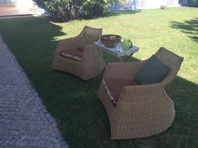 two chairs and a table on the grass at Casa de férias na Praia Verde Casa de Charme in Castro Marim