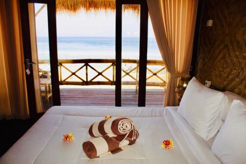 a room with a bed with a view of the ocean at Pondok Bamboo Villa in Nusa Penida