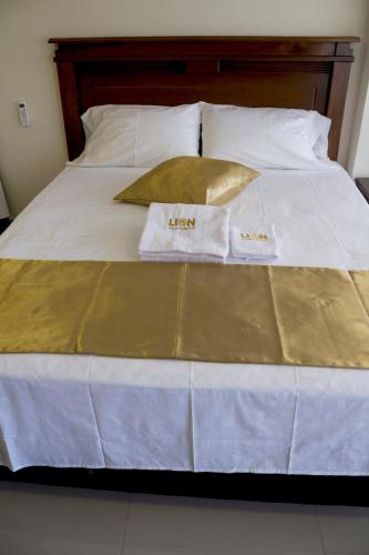 a bed with two towels on top of it at APARTAHOTEL LION in Tuluá