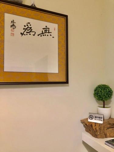 a picture hanging on a wall with a plant on a shelf at 飄流葉民宿 in Yuli
