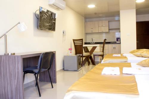 a room with four beds and a kitchen at APARTAHOTEL LION in Tuluá