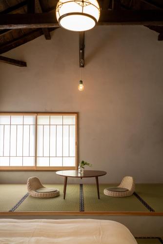 a room with a table and two chairs at ゑびすや in Kofu
