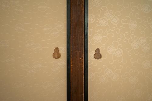a glass door with a floral pattern on a wall at ゑびすや in Kofu