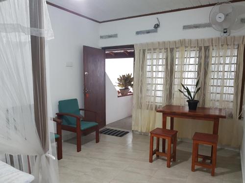 a room with a desk and a table and chairs at Moonray in Mirissa