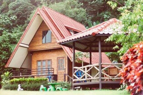 a house with a red roof and a playground at บ้านสวนศรเพชร in Phetchabun