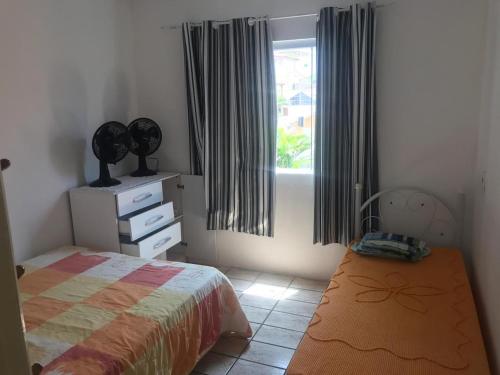 1 dormitorio con cama y ventana en Apto 4 pessoas 20m do mar 005, en Florianópolis