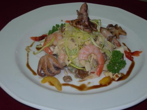 a white plate of food with shrimp and vegetables at Fontan in Chornomorsk