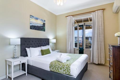 a bedroom with a large bed and a window at Ballina Heritage Inn in Ballina