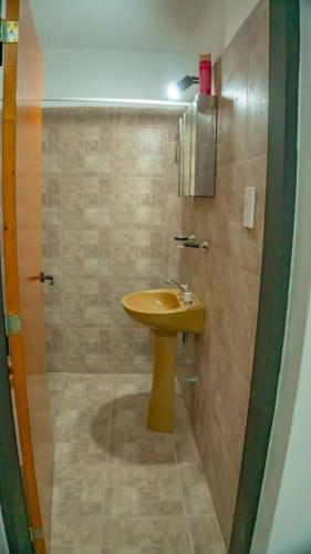 a bathroom with a yellow sink and a shower at Departamentos Shaka- Ekeikey in Belén