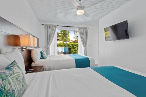 a hotel room with two beds and a tv at HOTEL MARINO BALLENA in Uvita