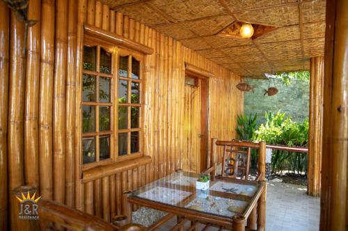 a dining room with a table and a wooden wall at J&R Residence in Anda