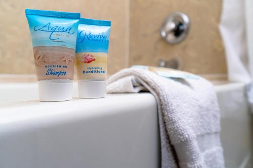 two tubes of sunscreen sitting on top of a tub at Sevilla Inn Kissimmee- Near Disney in Kissimmee