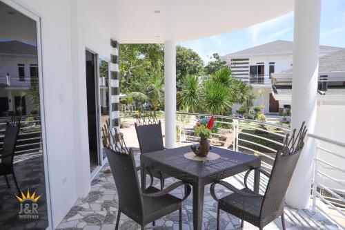 a patio with a table and chairs on a balcony at J&R Residence in Anda