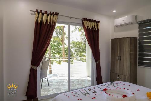 a bedroom with a bed and a sliding glass door at J&R Residence in Anda