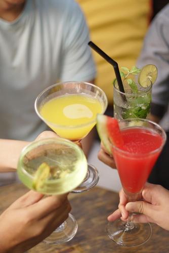 a group of people holding up drinks on a table at Kosenda Hotel in Jakarta