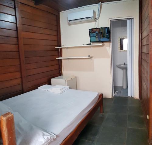 a small room with a bed and a sink at Recanto dos Albatrozes in Boicucanga