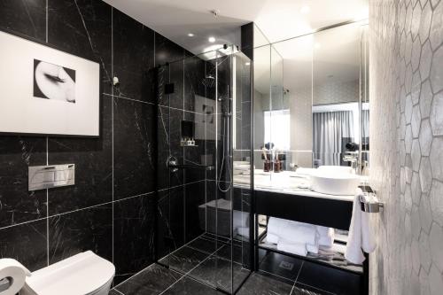 a bathroom with a shower and a toilet and a sink at Fable Dunedin in Dunedin