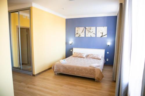 阿克托比的住宿－Sad Dolgoletiya Hotel，一间卧室设有一张床和蓝色的墙壁