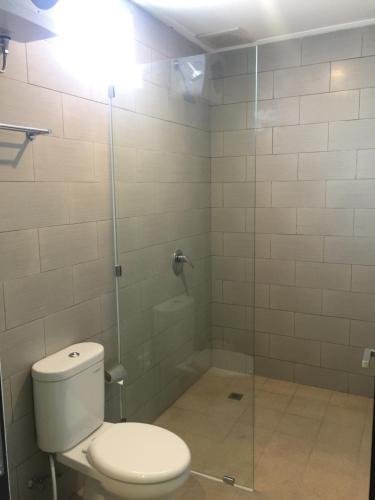 a bathroom with a toilet and a shower at Grey House Monkey Forest in Ubud