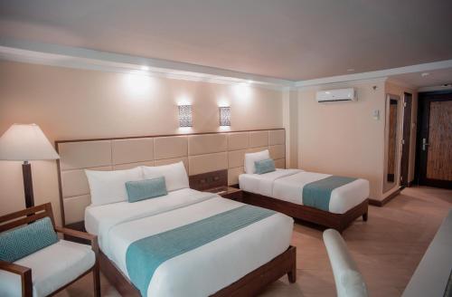 a hotel room with two beds and a chair at Boracay Mandarin Island Hotel in Boracay