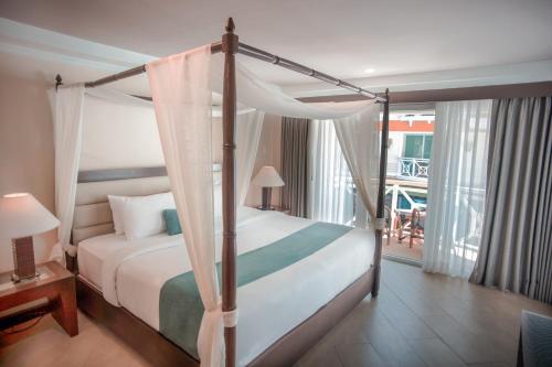 a bedroom with a canopy bed and a balcony at Boracay Mandarin Island Hotel in Boracay