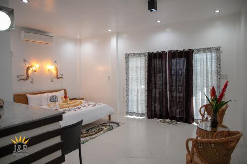 a bedroom with a bed and a desk and a window at J&R Residence in Anda