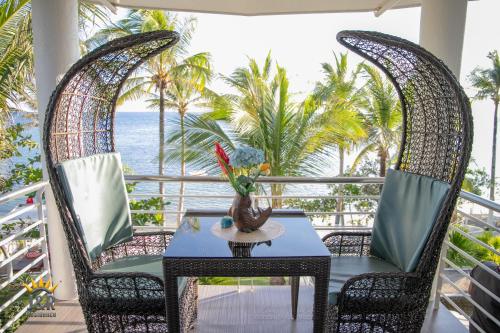 a table and chairs on a balcony with the ocean at J&R Residence in Anda