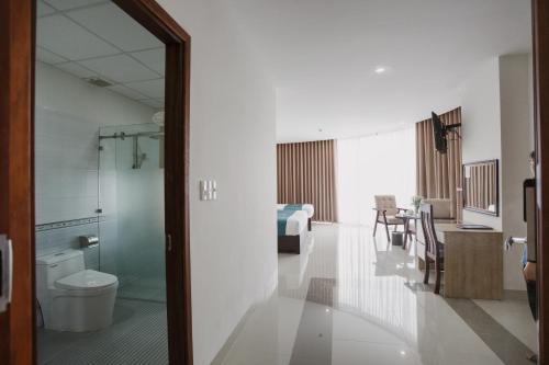 baño con aseo y habitación con cama en Ban Me Central Hotel en Buon Ma Thuot
