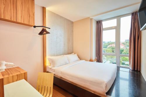 a hotel room with a bed and a window at ibis budget Singapore West Coast in Singapore