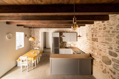 a kitchen and dining room with a table and a counter at Mulberry Stonehouse in Primošten