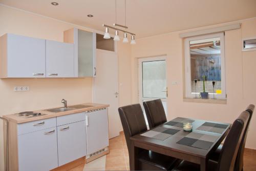 cocina y comedor con mesa y sillas en Alt Baden Apartement, en Dunaszekcső