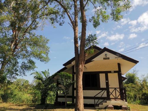 a house with a tree in front of it at RS Phong Riverside Resort in Khon Kaen