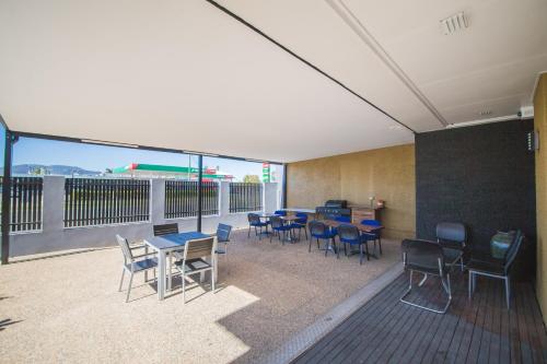 a room with tables and chairs on a balcony at Metro Motel Rockhampton in Rockhampton
