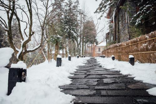 a stone path covered in snow next to a fence at Evergreen Retreat-walk to National Forest Park, free pick up service in Zhangjiajie