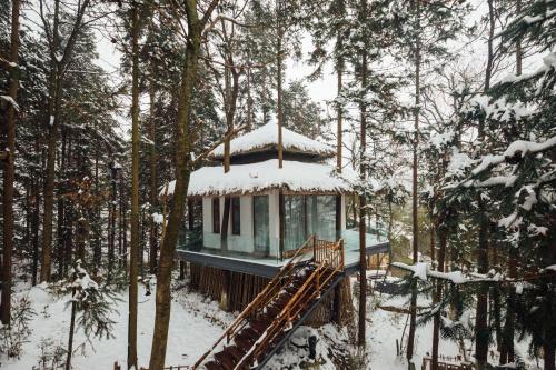a tree house in the woods in the snow at Evergreen Retreat-walk to National Forest Park, free pick up service in Zhangjiajie
