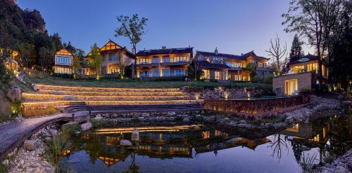 a large house with a lake in front of it at Evergreen Retreat-walk to National Forest Park, free pick up service in Zhangjiajie