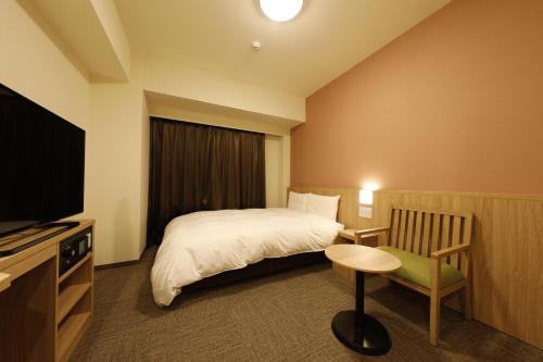 A bed or beds in a room at Dormy Inn Mito