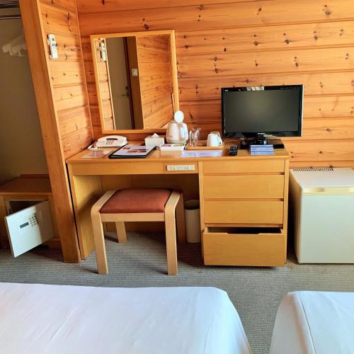 a bedroom with a desk with a computer and a tv at Grand Park Hotel Okubiwako Makino in Takashima
