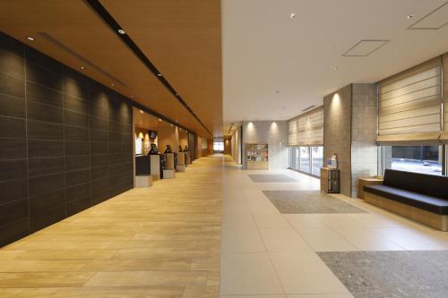 two images of a hallway in a building at Dormy Inn Mito in Mito
